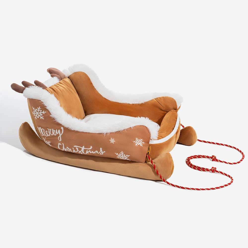 Christmas-themed dog bed in sleigh design featuring soft red fabric and decorative rope accents.