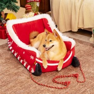Festive plush cozy dog bed styled as a holiday sleigh with a medium dog relaxing inside.